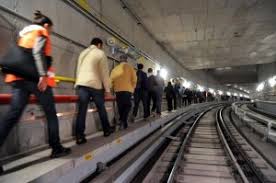 persone che camminano in fila nella galleria di una metropolitana per gestione di una emergenza